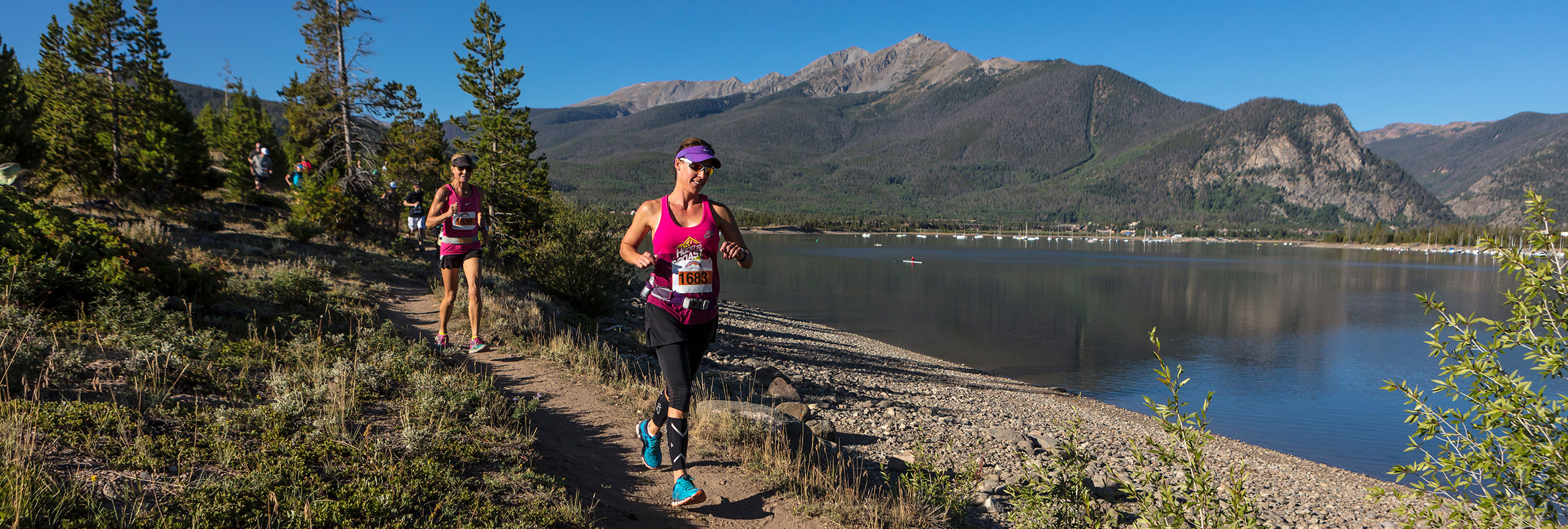 Two runners on a trail by Lake Dillon